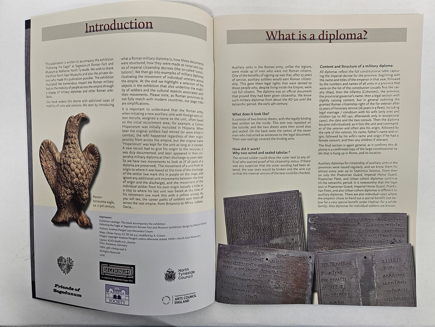 An open booklet or brochure spread showing printed text pages titled 'Introduction' and 'What is a diploma?' with several small diploma sample images attached along the bottom right edge and a Roman Eagle.