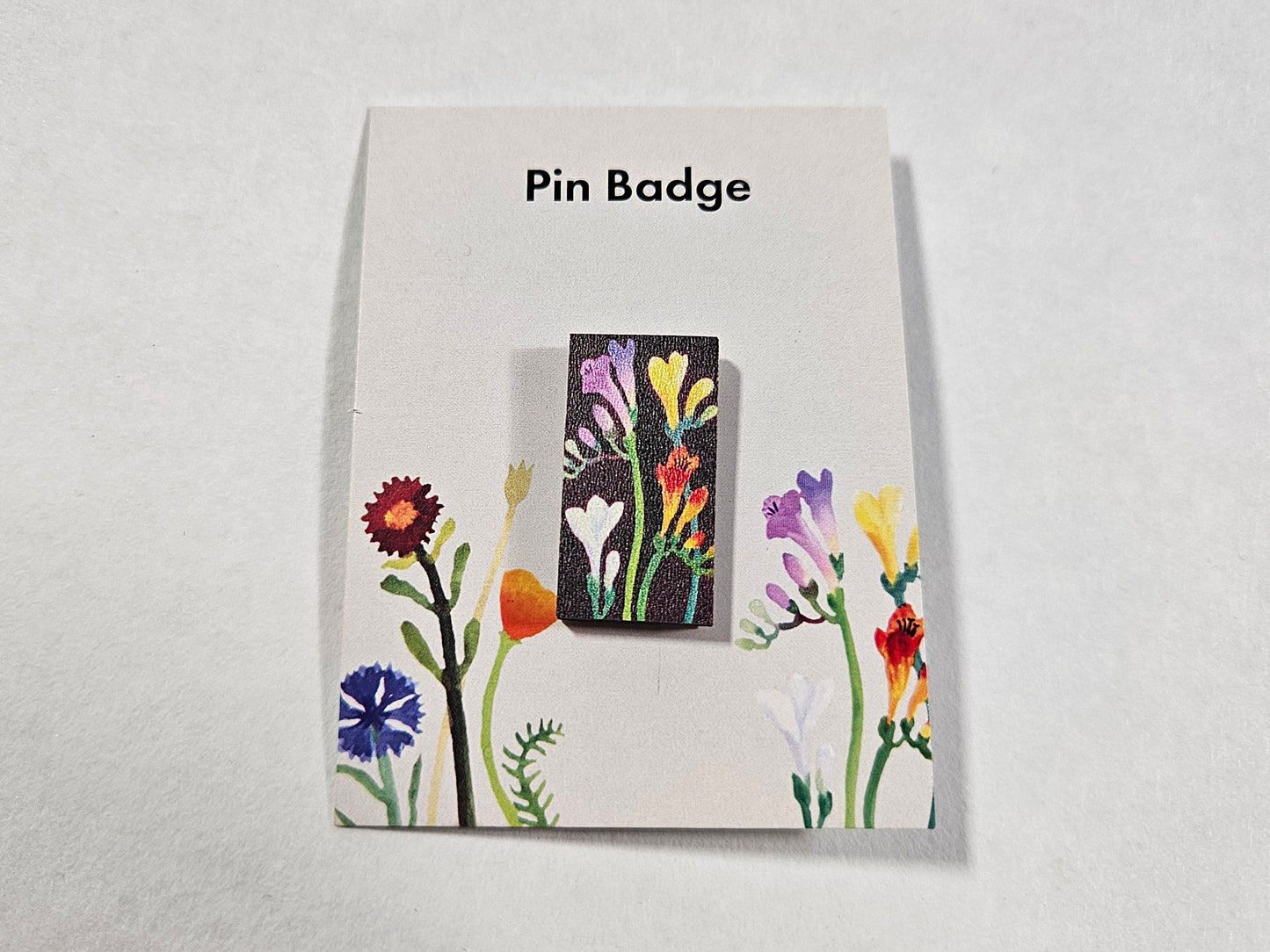 Floral pin badge on a white card with 'Pin Badge' text on a light gray background
