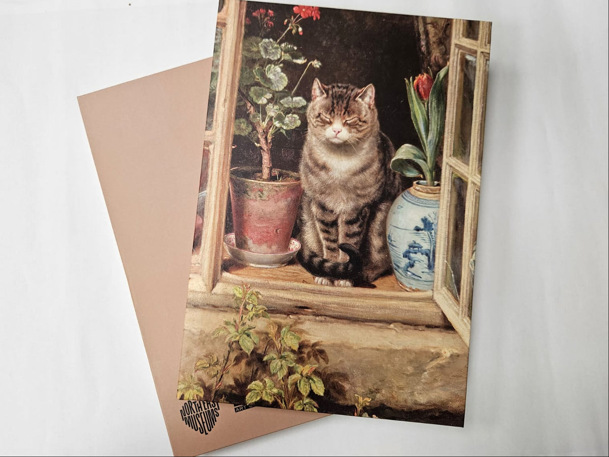 Notebook featuring a tabby cat sitting by an open window beside potted plants including a tulip and geranium.