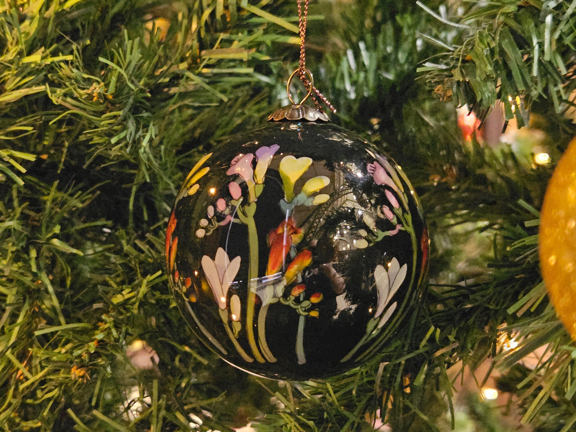 Decorative Christmas ornament with floral design on a tree