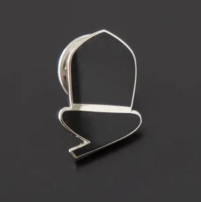 Acorn shaped pin badge on a black background