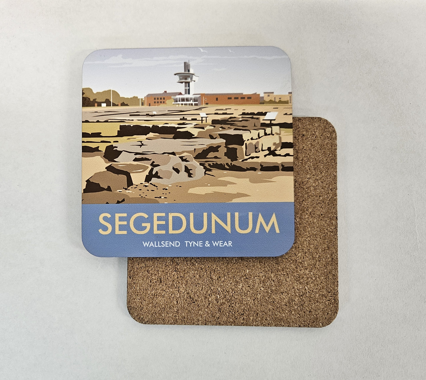 Two square coasters on a light surface. The top coaster shows a stylized illustration of Segedunum ruins with a blue band at the bottom reading “SEGEDUNUM” and smaller text “WALLSEND TYNE & WEAR.